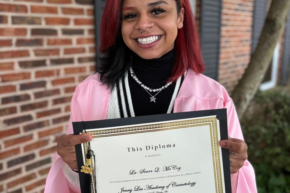 Beauty school graduate holding diploma after completing training program