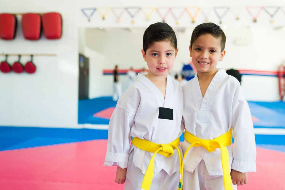 Happy young boys smiling and looking cheerful while having a martial arts practice