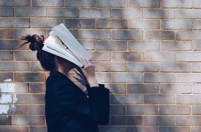 Girl with book on face 