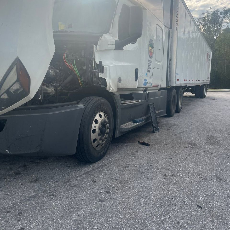 White Freightliner semi-truck with hood open during roadside diesel repair in Arab Alabama