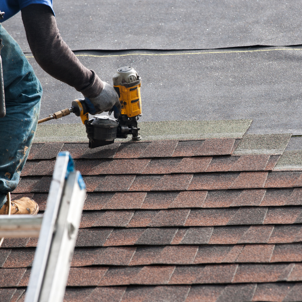 Roofing contractor installing architectural asphalt shingles during a residential roof replacement by E & D Roofing, Inc.