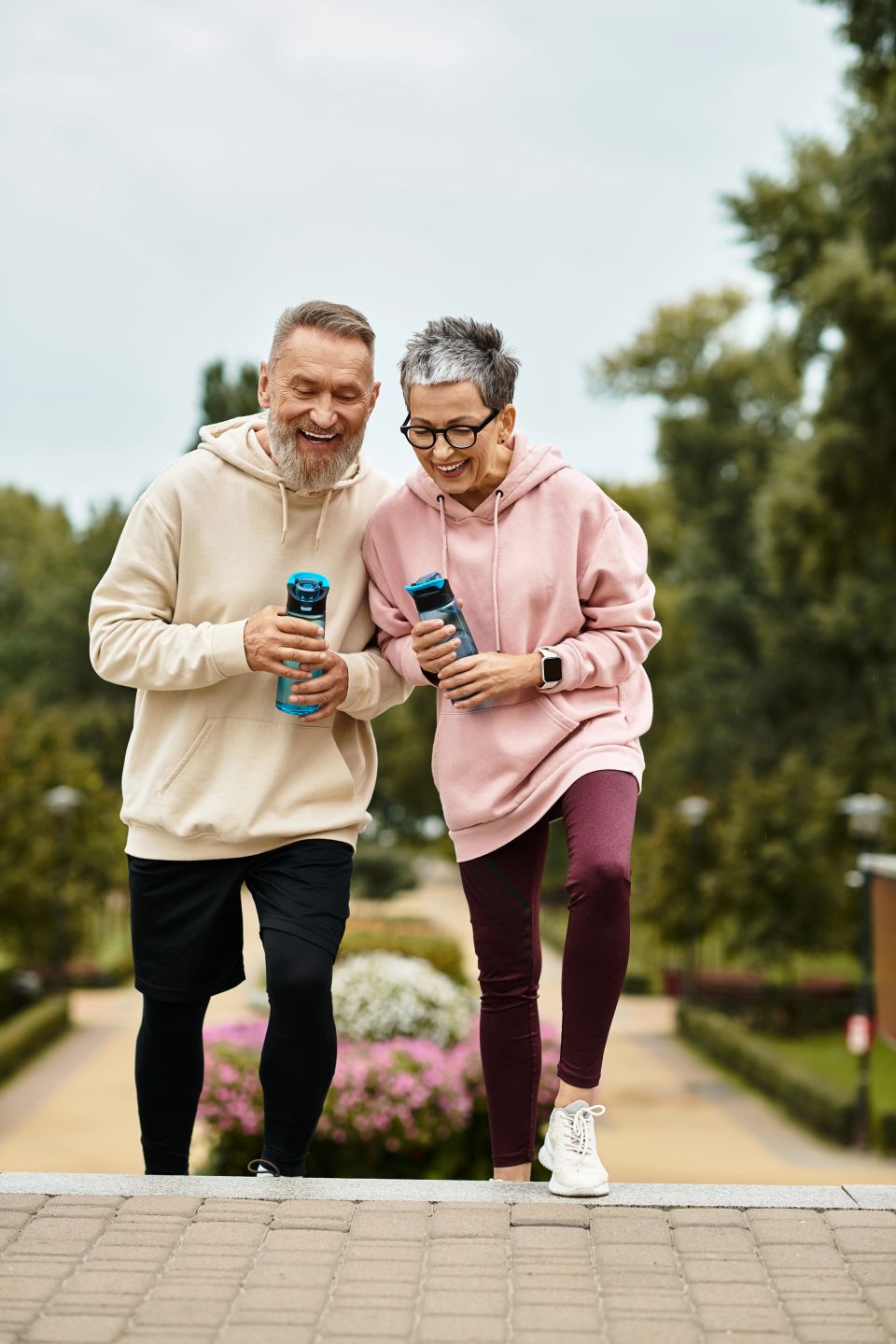 A couple enjoys a sunny day in the park, laughing and sipping drinks together