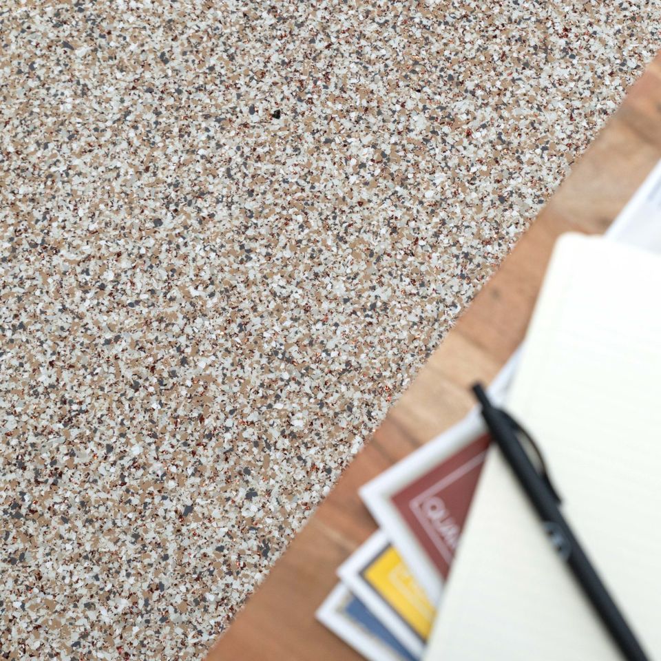 Close-up view of EverStone Flakes flooring with a speckled finish.