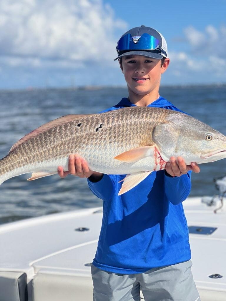 Young angler proudly holding a large redfish on the charter boat Charleston SC