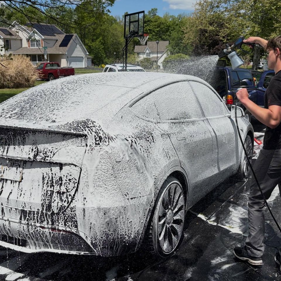 Foam cannon pre-wash covering the rear of a Tesla Model Y during exterior cleaning
