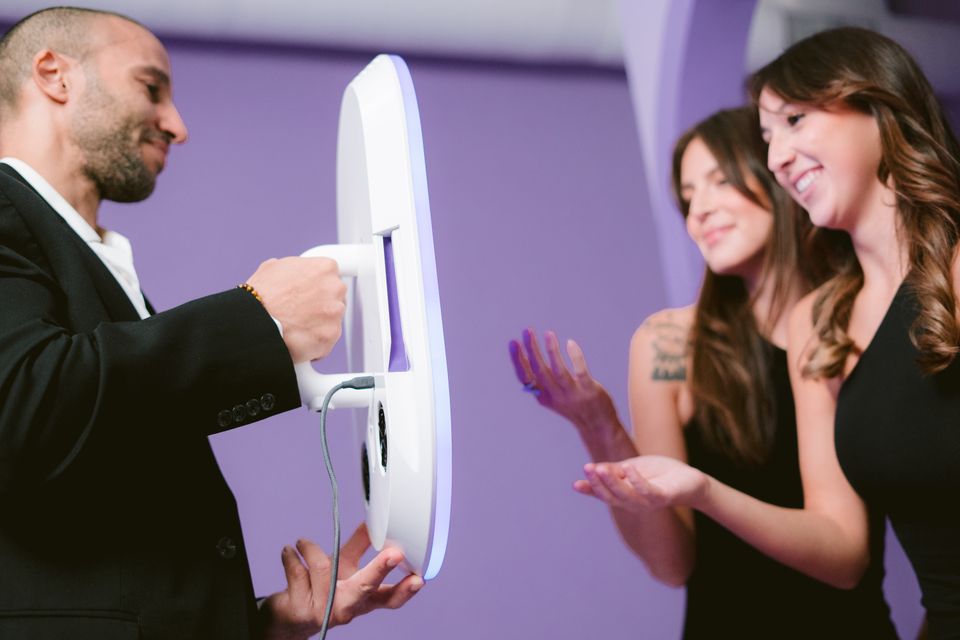 Guests posing and smiling in front of a Roaming Photo booth