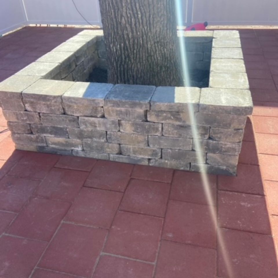 "Stone retaining wall encircling a tree, built by Gabino Landscaping in Myrtle Beach, South Carolina."