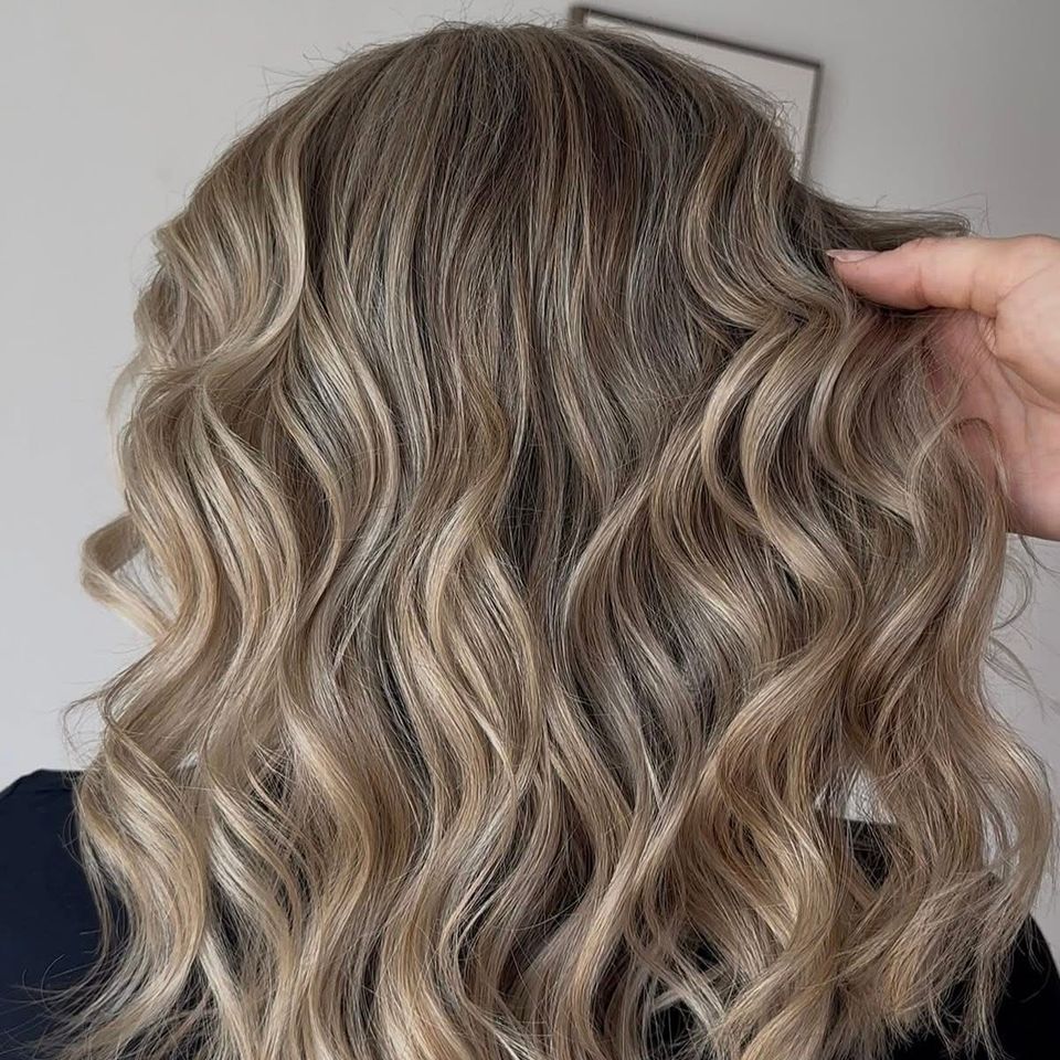 Medium wavy bronde hair with dimensional blonde highlights after color service in Columbiana AL
