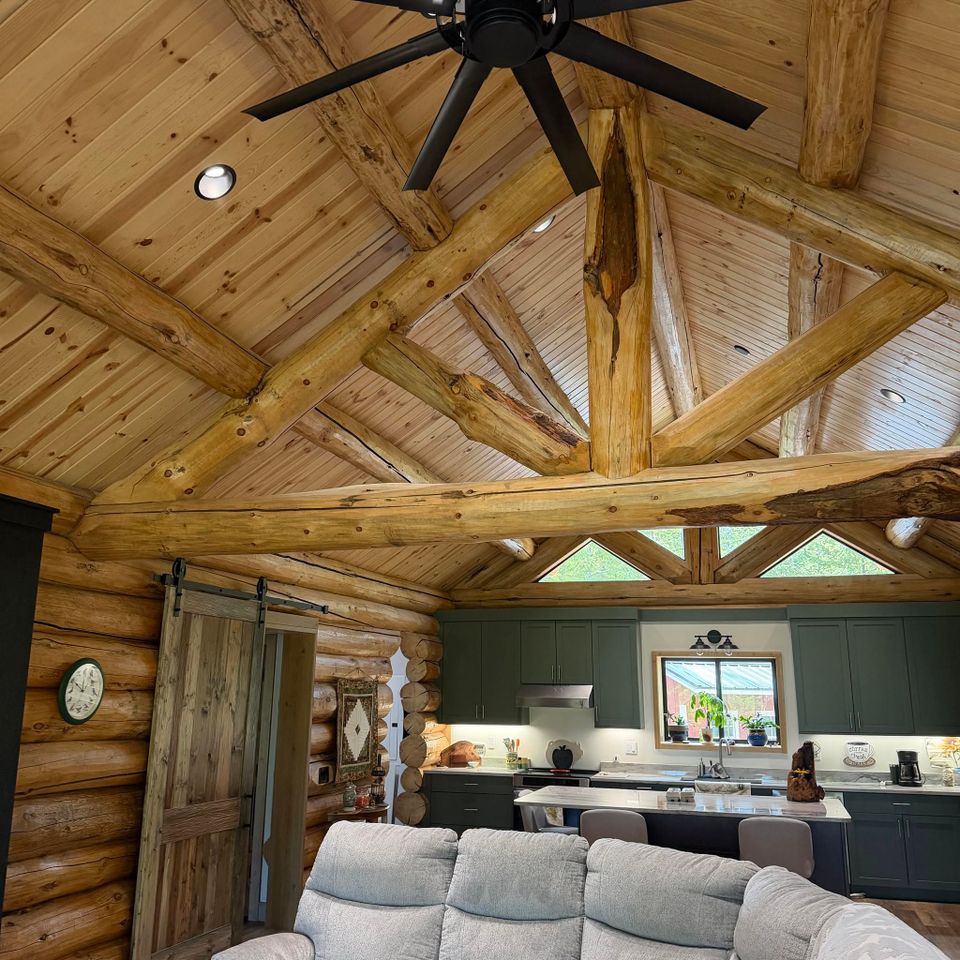 Vaulted log truss ceiling and open kitchen inside a custom log home in Trout Creek MT