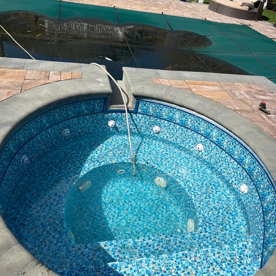 Tiled spa with jets beside a covered inground pool during a pool opening in Long Island NY