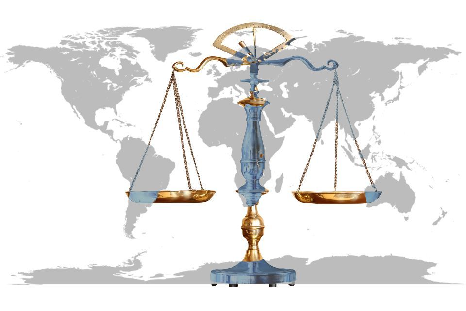 scales of justice foreground with world map backdrop