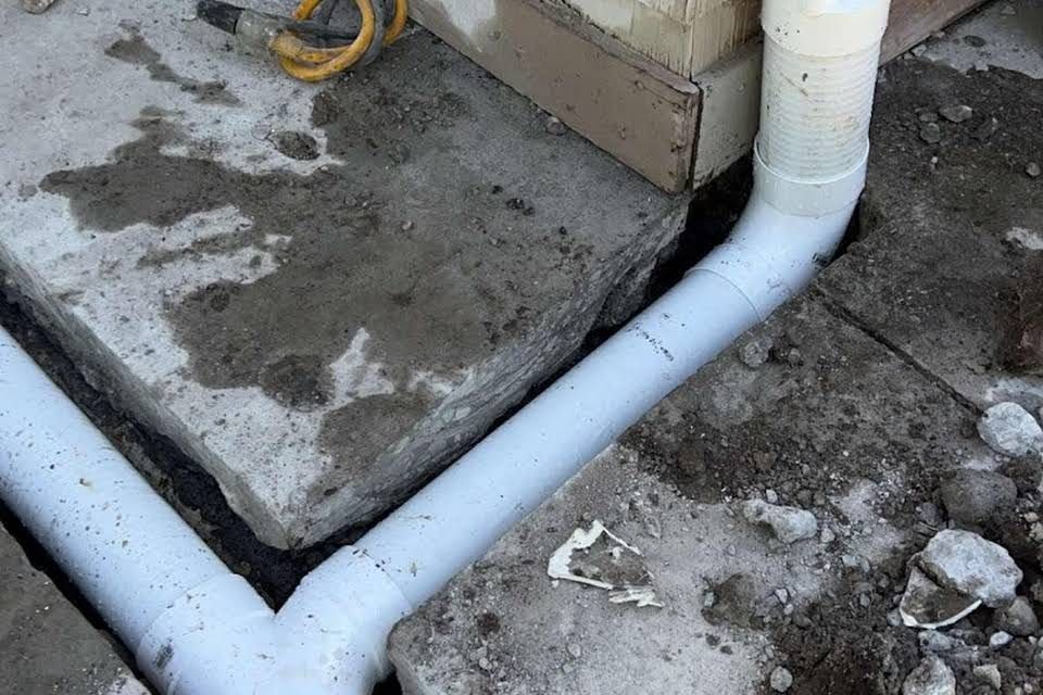 Cut out of concrete for gutter extension and driveway drain