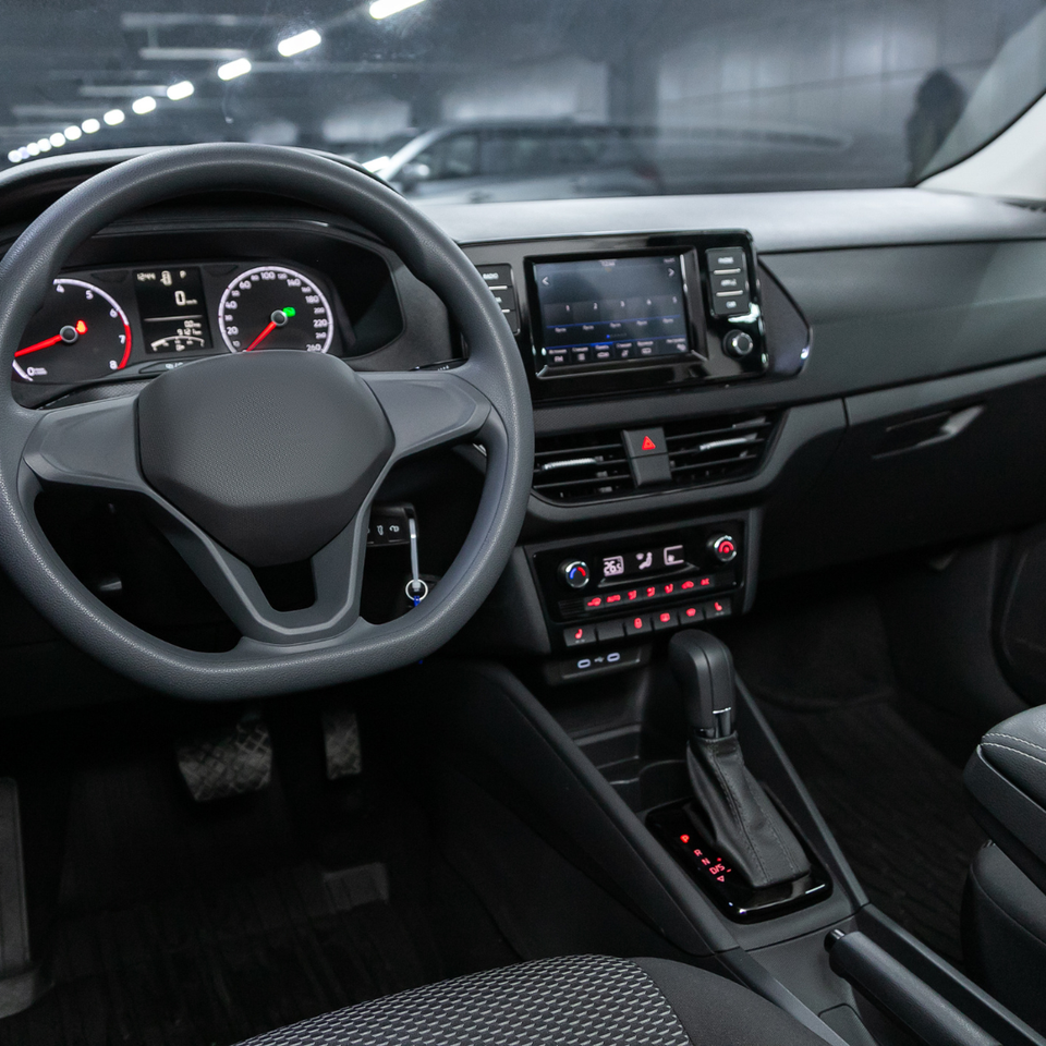 Interior view of a modern vehicle featuring the dashboard, steering wheel, center console, and infotainment system.