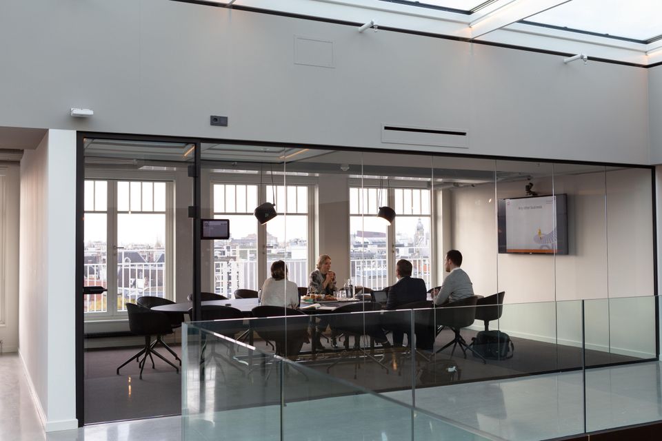 business meeting taking place in a conference room overlooking outdoors