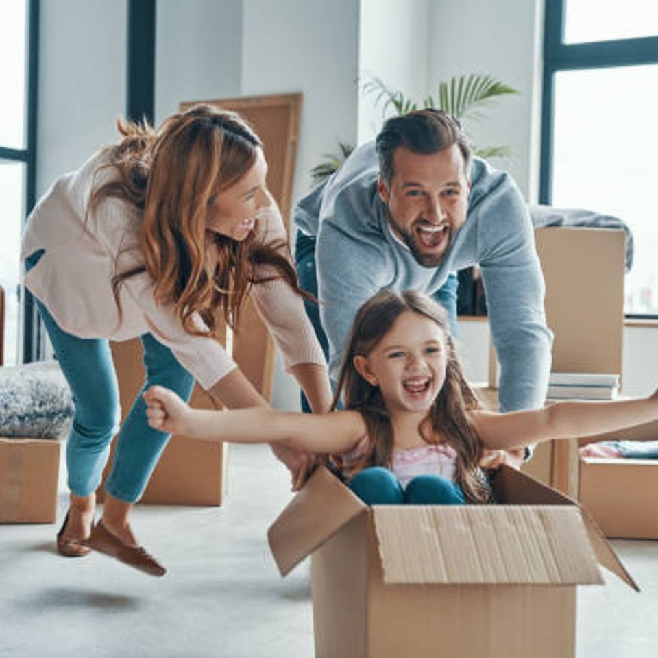 Mom and dad playing with daughter in a box