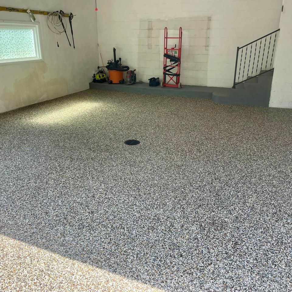 Residential garage with a decorative EverStone Epoxy Stone floor and built-in floor drain.