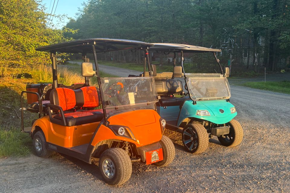 Orange and blue golf cart rental in the sunset from Mad Dog Golf Cart Rentals in Arrowhead Lake PA