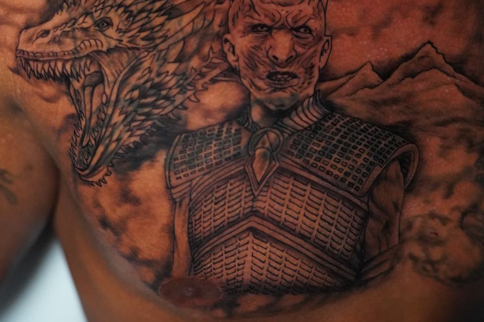 Image of a tattoo of a demon with his trusty dragon in black and grey with mountains in the background