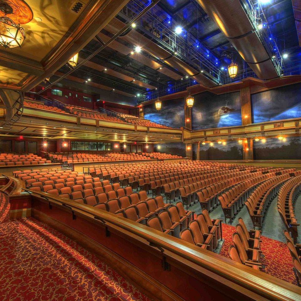 Beautiful empty venue with red carpet and seats and a balcony.