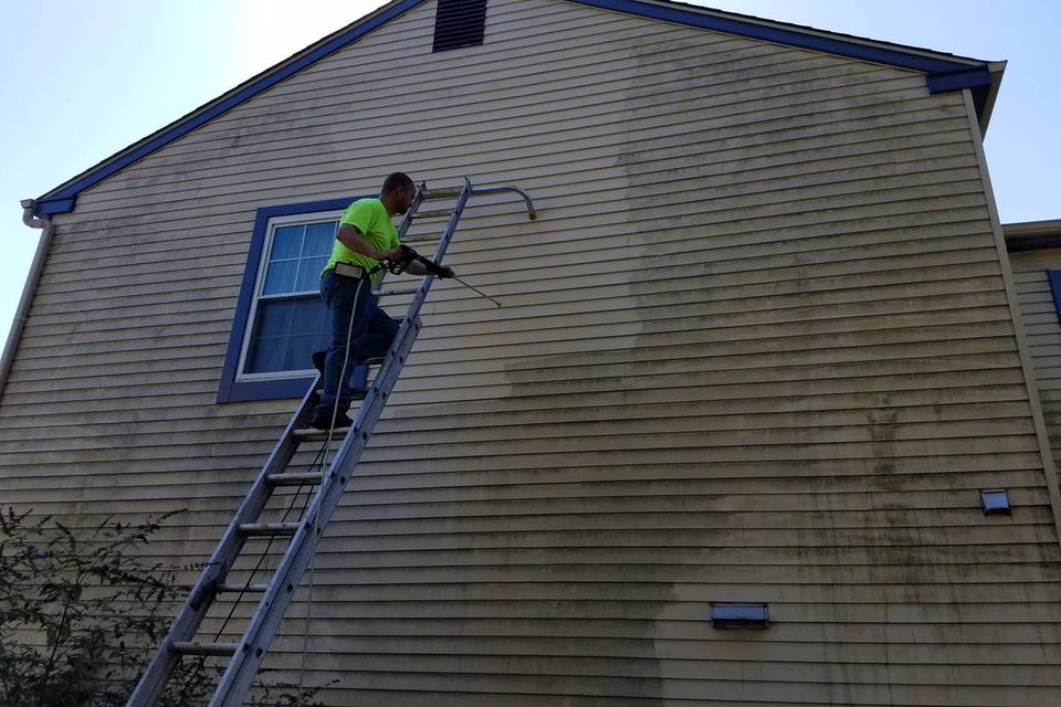 Owner Virgil, power washing a house