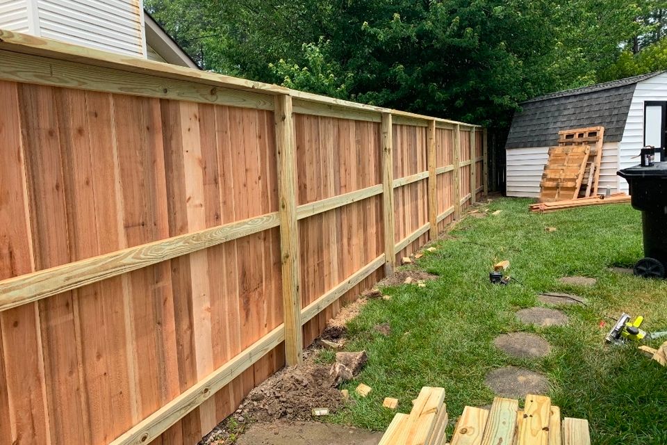 Cedar wood privacy fence with cap rail and trim installed along side yard in Virginia Beach VA