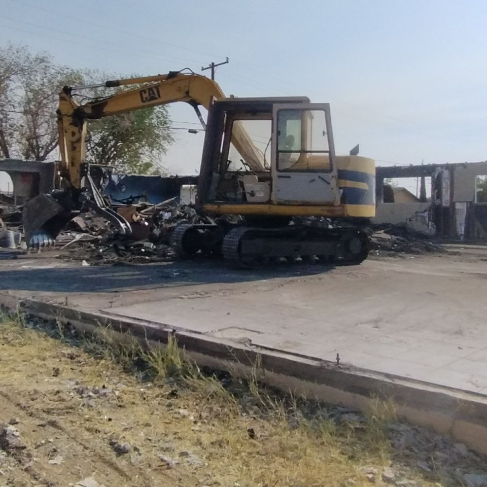 Image of a slab and walls about to ghet dropped and hauled away as part of this demolition project