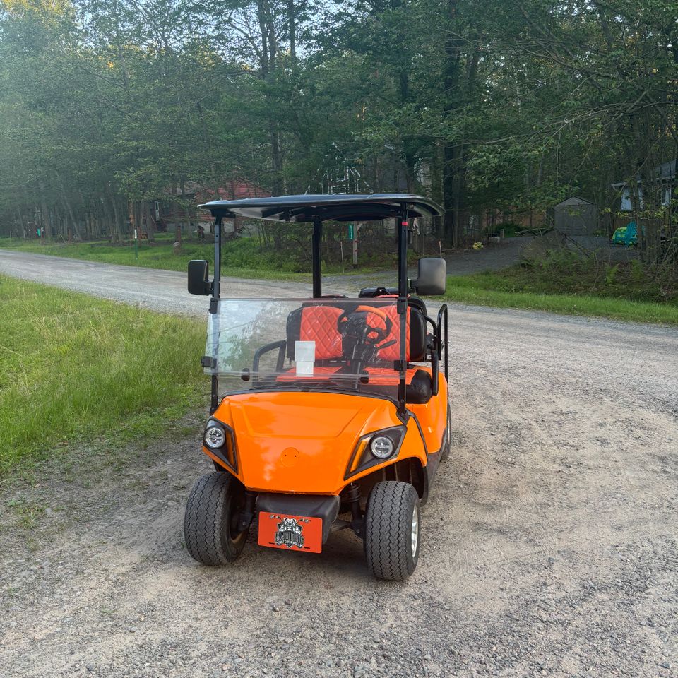 Front view of an affordable orange golf cart rental from Mad Dog Golf Cart Rentals in Locust Lake PA