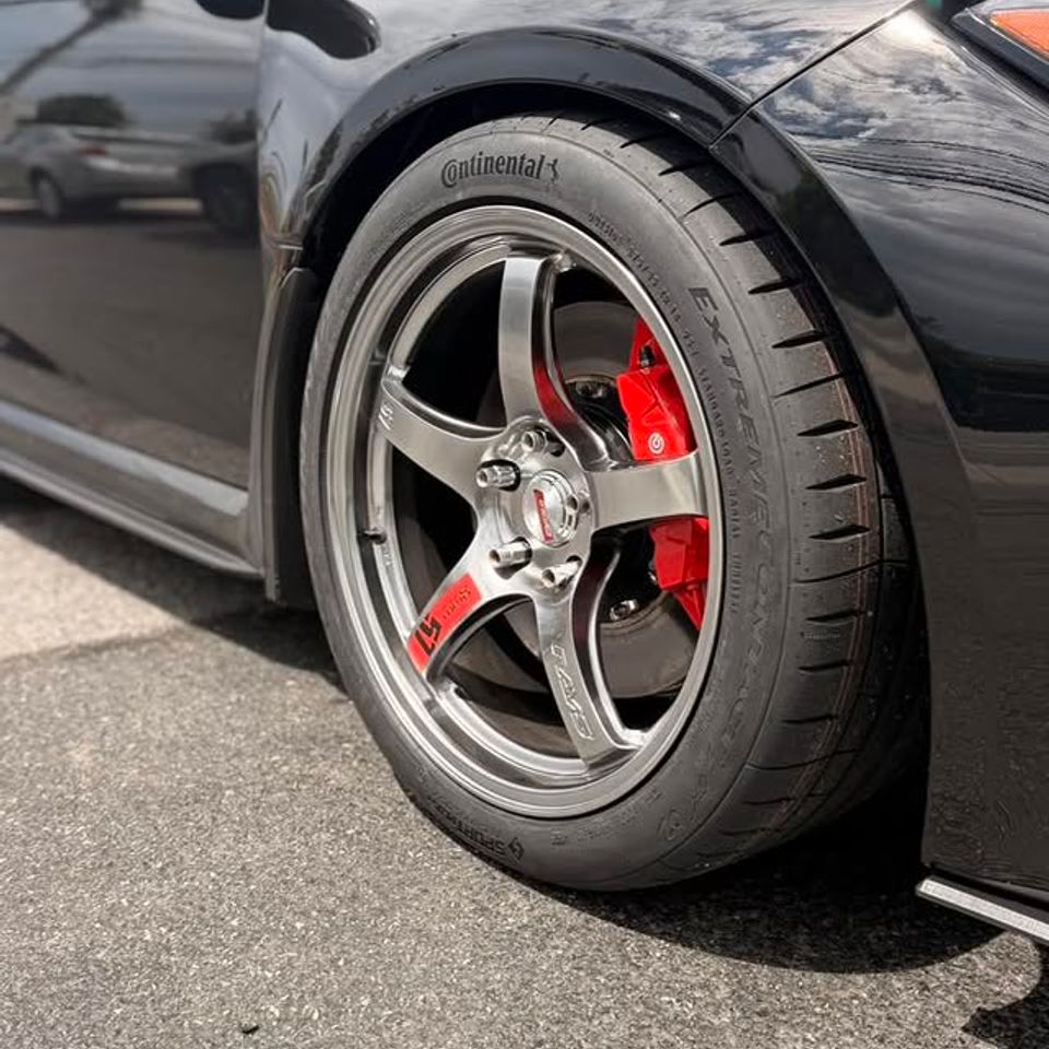 Close-up of sports car wheel with Continental tire and red Brembo brake caliper in Claymont DE