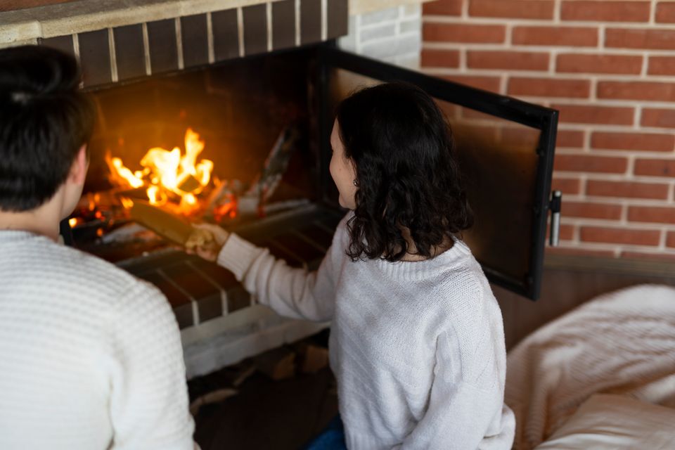 High angle woman putting wood fireplace