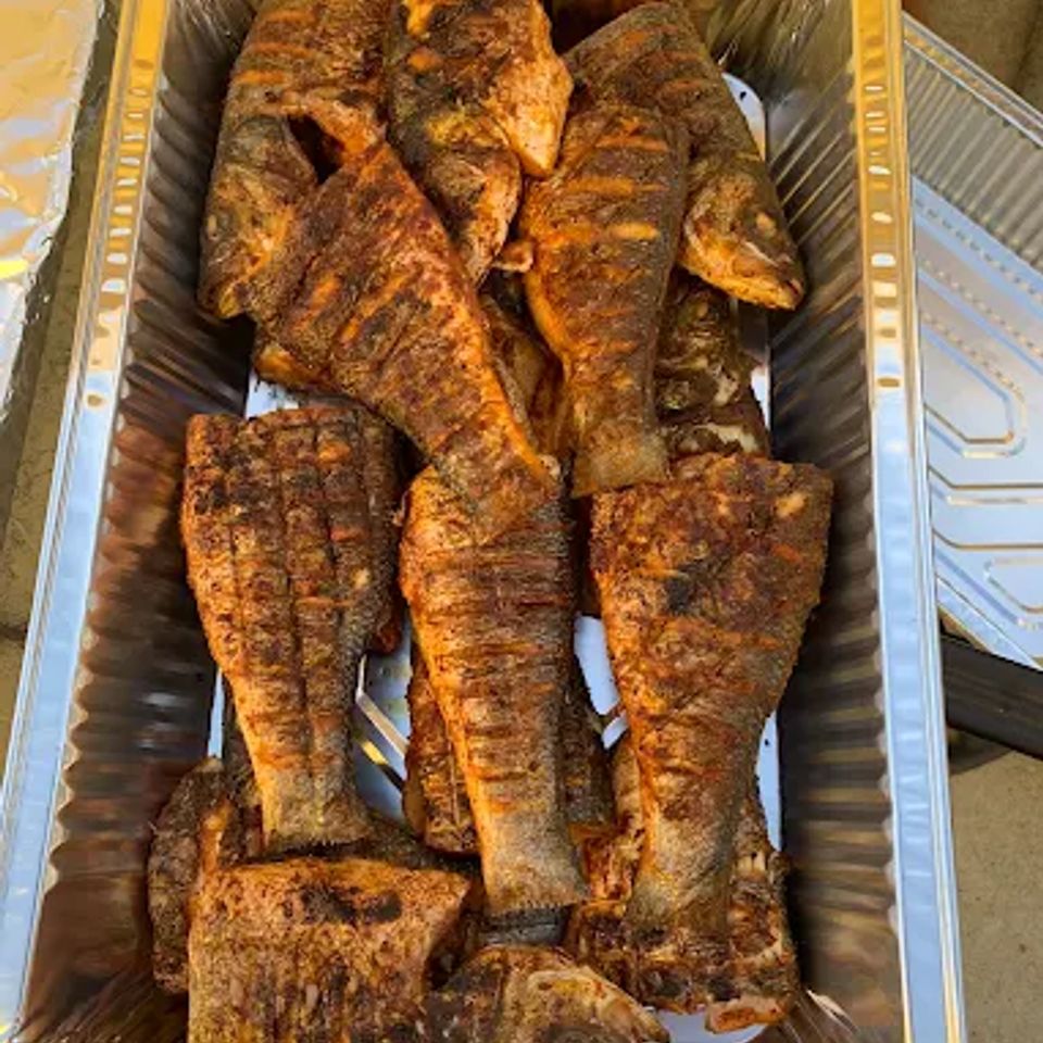 Catering tray of seasoned grilled whole fish prepared for a Los Angeles CA party