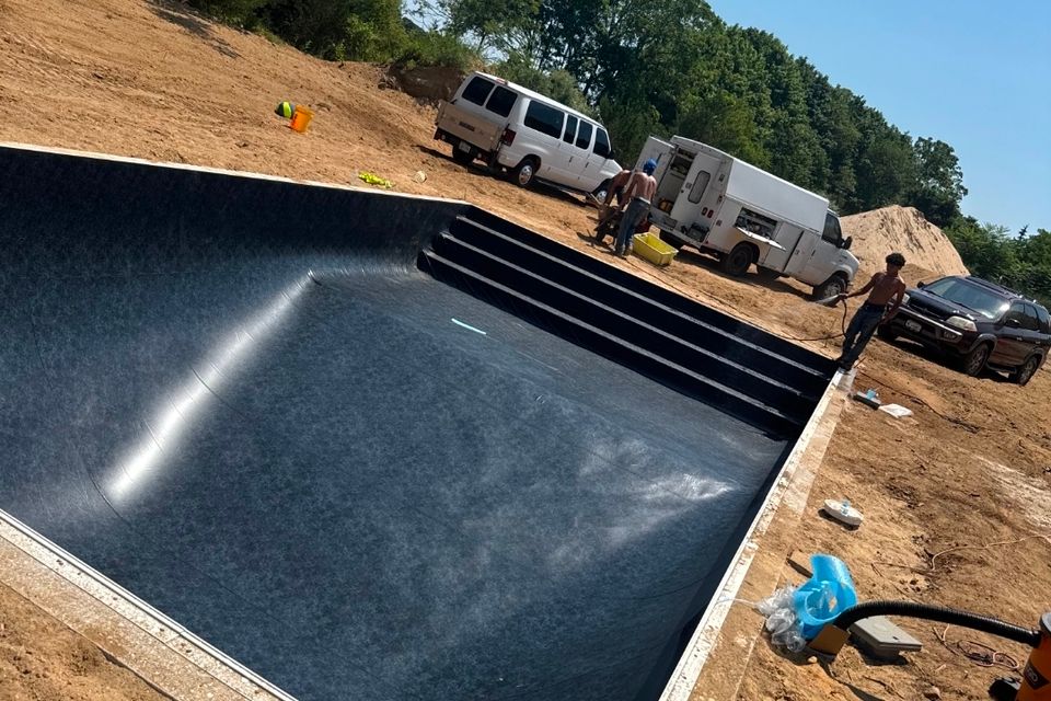 New black pool liner installed in an inground pool shell during construction on Long Island
