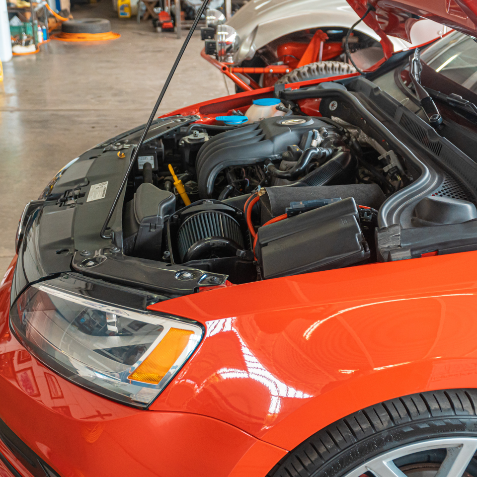 Vehicle engine compartment undergoing engine repair and replacement service.