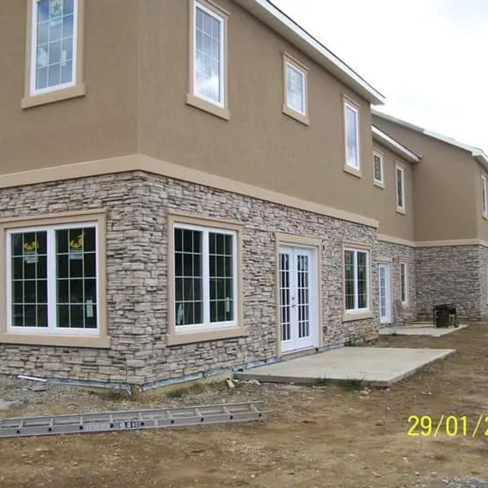Two-story building with light-colored veneer stone covering the lower exterior walls.