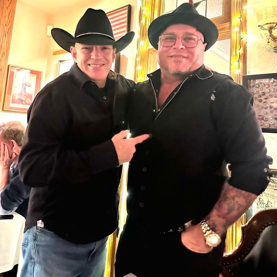 Two Roadside band members in cowboy hats posing together at a Long Island event venue