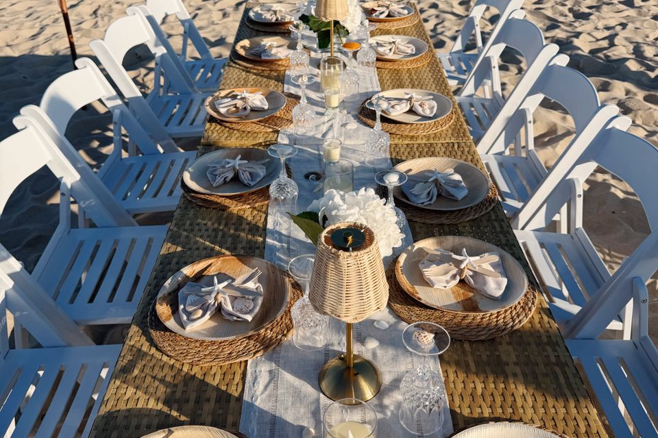 Overhead view of a seaside dinner table with shell napkin details and rattan lamps in the Hamptons NY