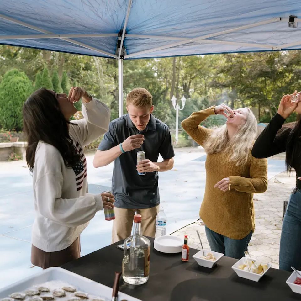People enjoying themselves at a raw bar catering event, catered by Shore2Shore Shucking of Long Island