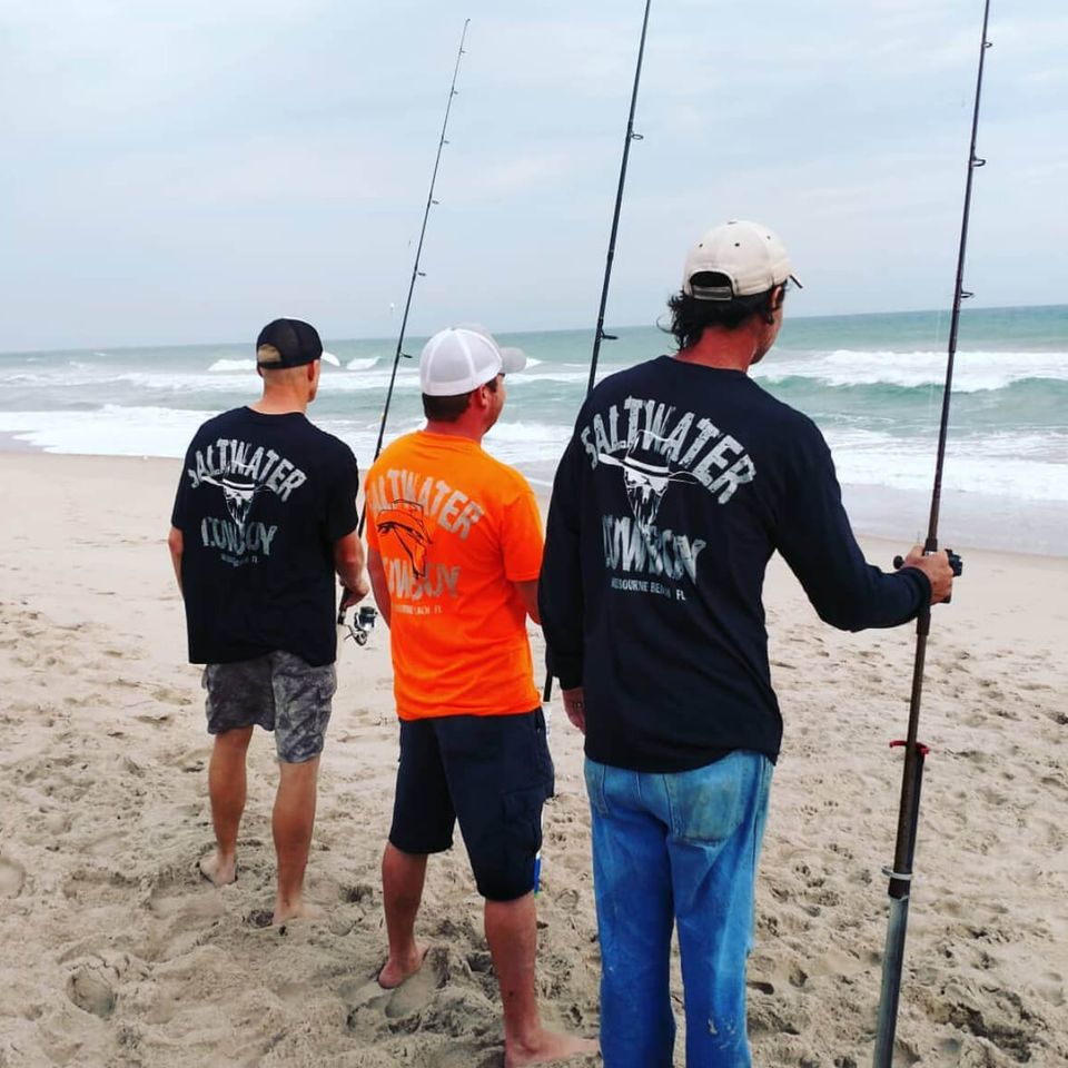 Fishermen holding rods and reels on the beach