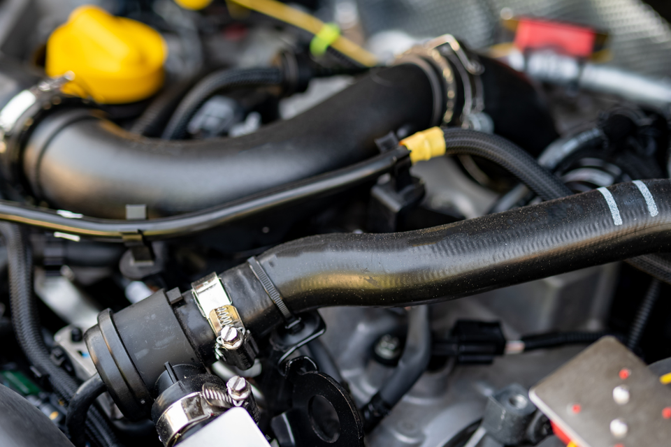 Close-up of a vehicle engine compartment during minor electrical repair service.