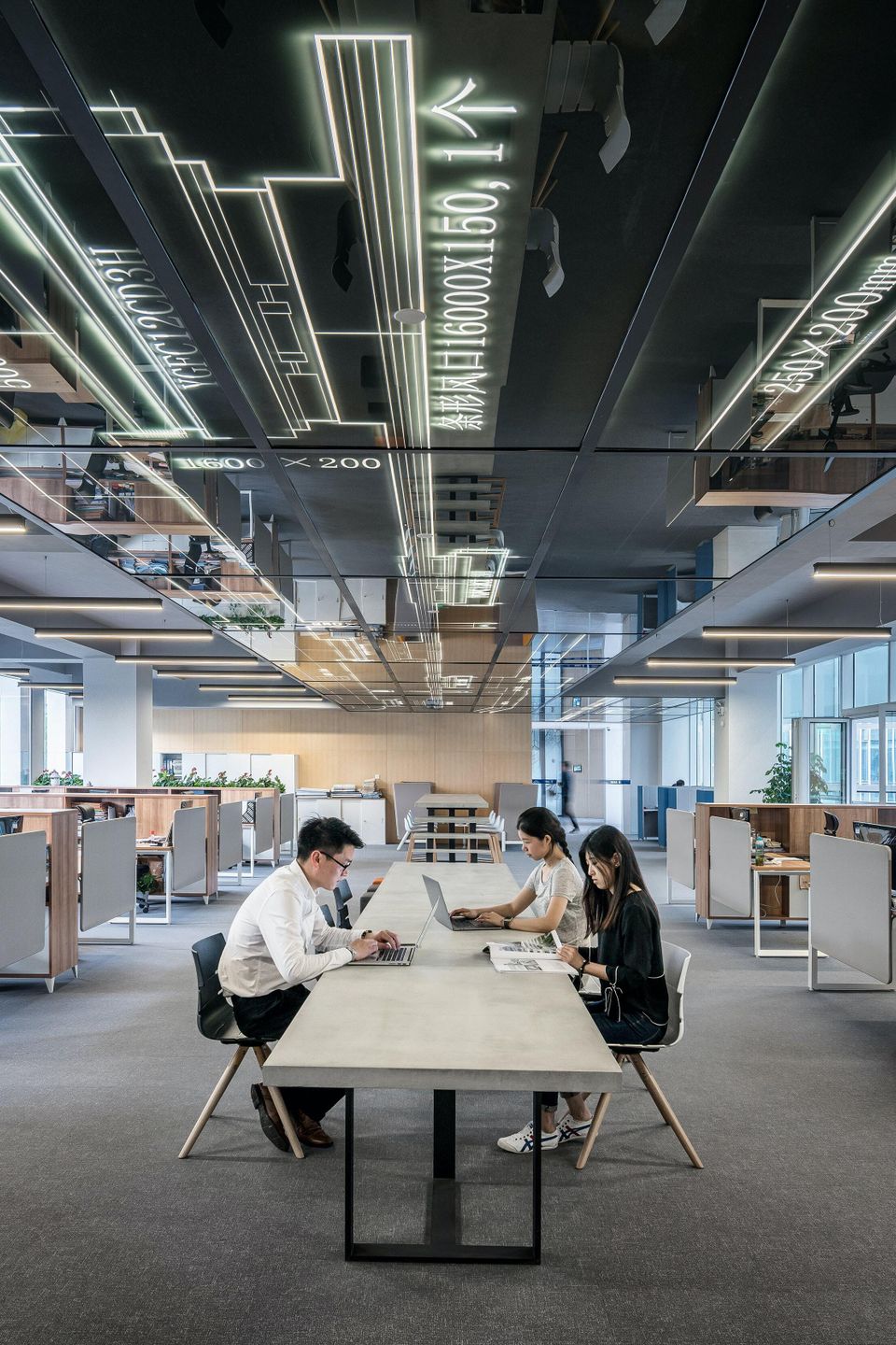 Interior office building cubicles and people working at desks