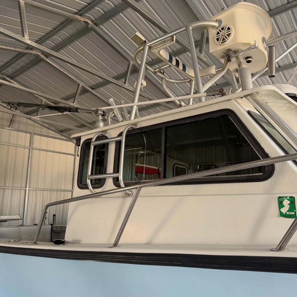 White center console boat with tinted cabin windows inside a storage building