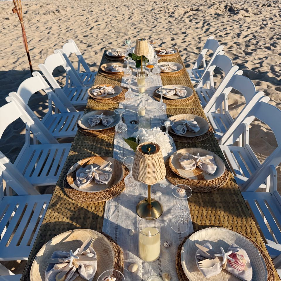 Overhead view of a seaside dinner table with shell napkin details and rattan lamps in the Hamptons NY