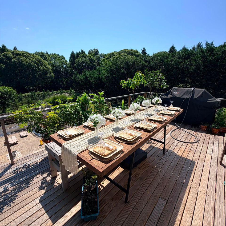 Outdoor table styling with hydrangea centerpieces on a sunny backyard deck in the Hamptons NY