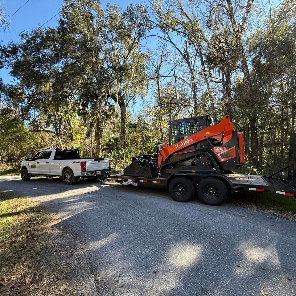 JNJ Hauling Solutions hauling a kubota with their truck