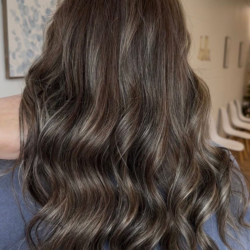 Long wavy dark brown hair with soft dimensional highlights after color and styling in Columbiana AL