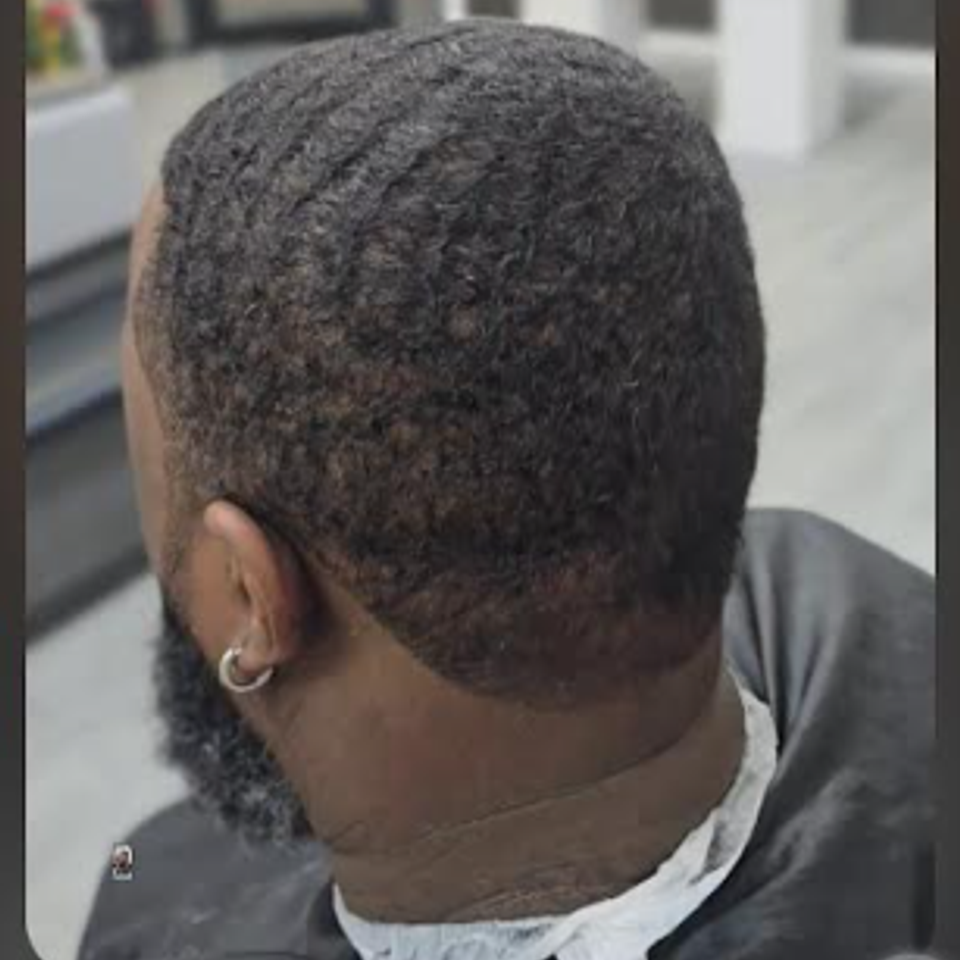 Back view of a wave haircut with taper fade by Jeff Barber Services in The Bronx