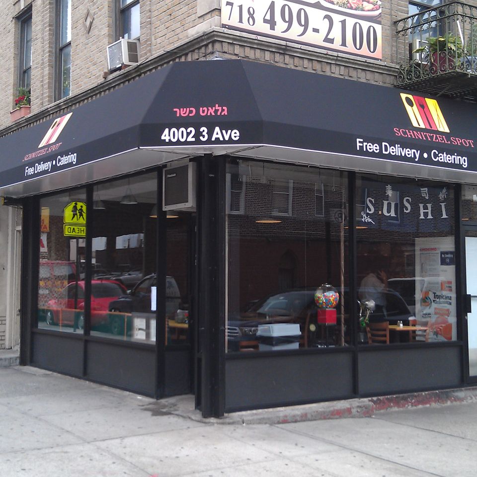 Black corner awning wrapping two sides of the storefront.