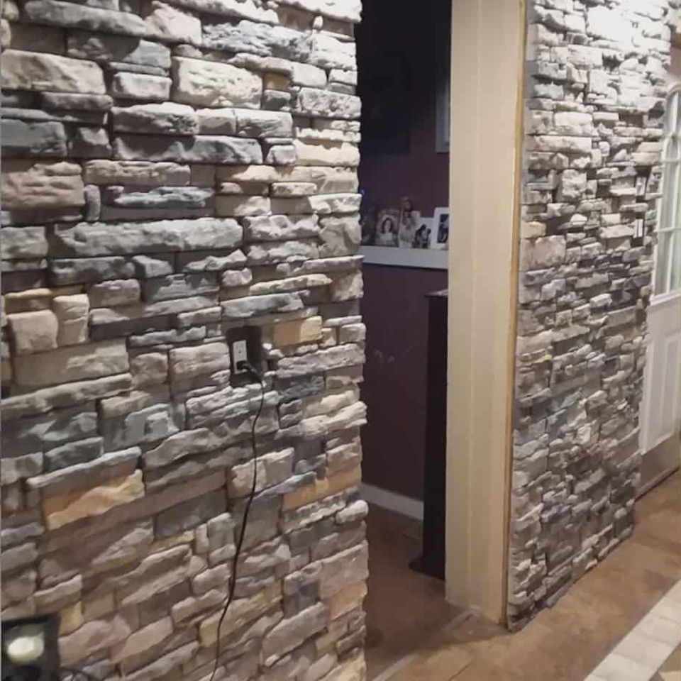 Interior wall featuring gray and beige veneer stone around a doorway.