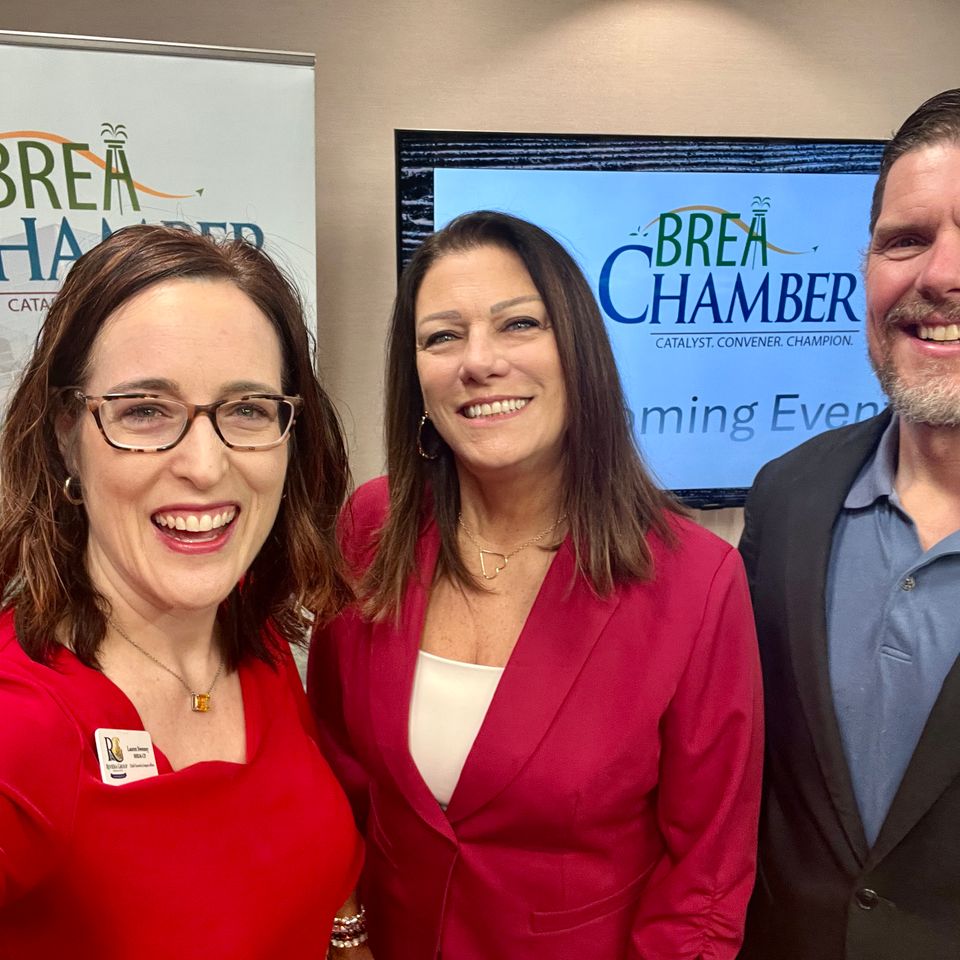 Two women and a man posing at an event