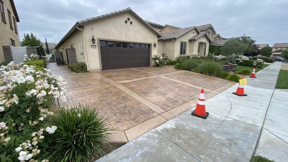 Stamped concrete driveway with custom border design in front of residential home