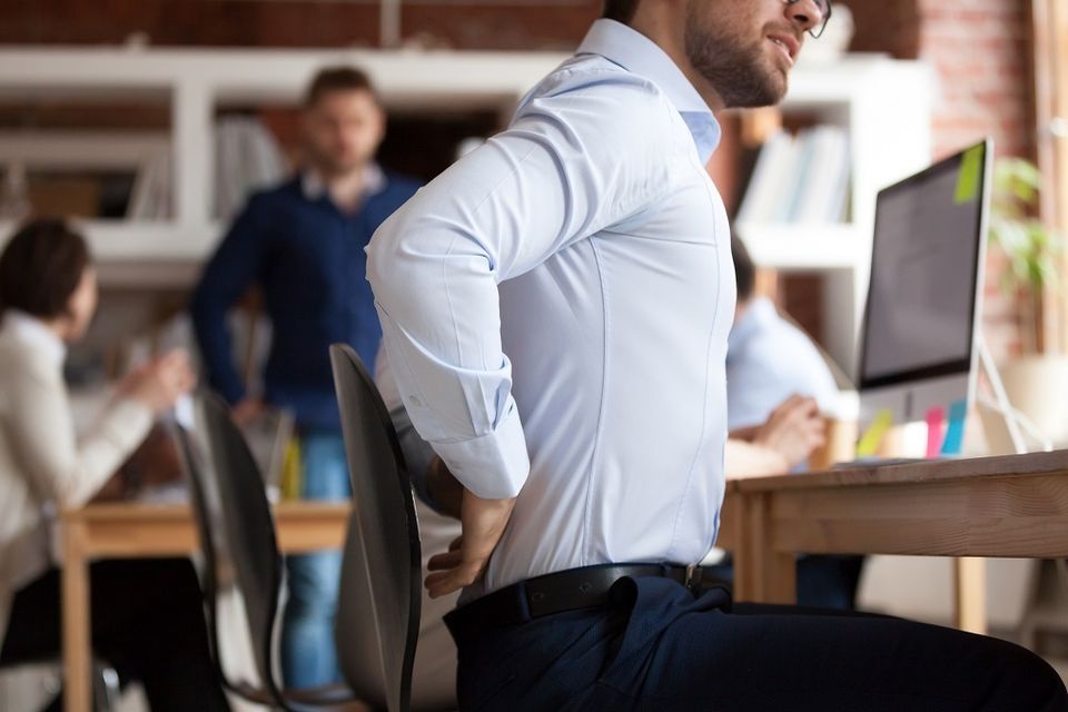 Man with chronic back pain at work